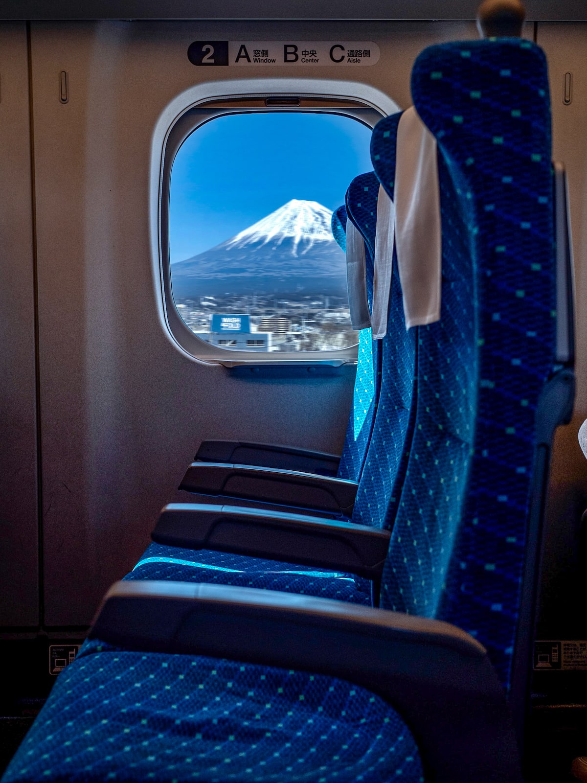 Train seats next to the window, which shows a striking snow-capped mountain.