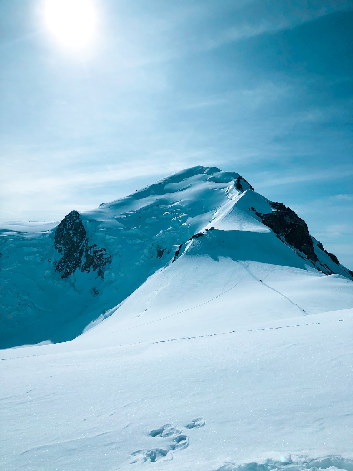 A snowy mountain with footprints from hikers.