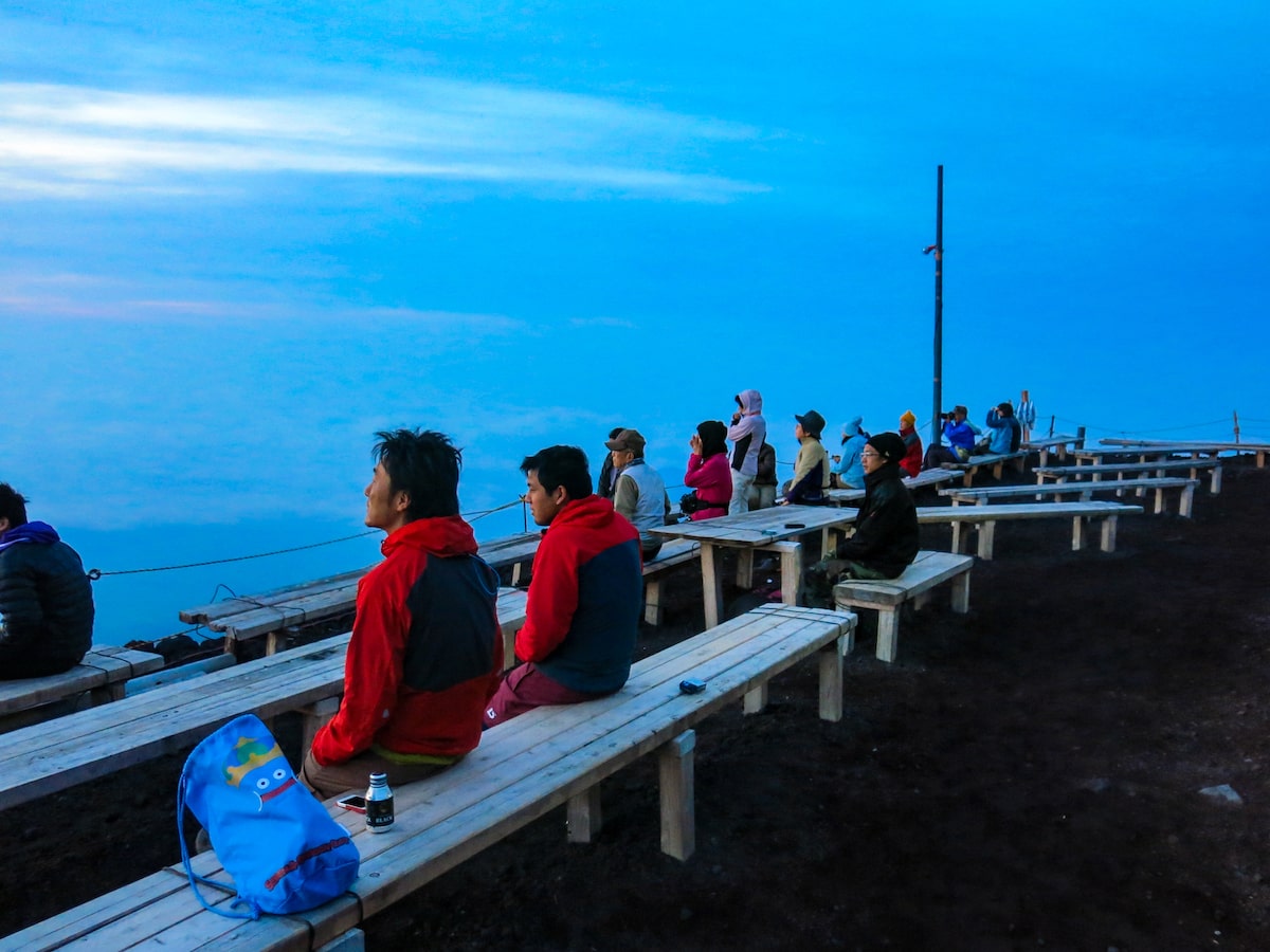 Climbers on Mount Fuji sit and wait patiently for the sunrise.