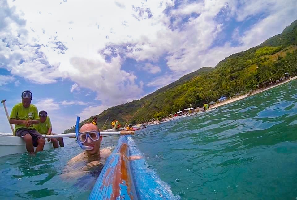 Man smiling in water with a snorkel set on.