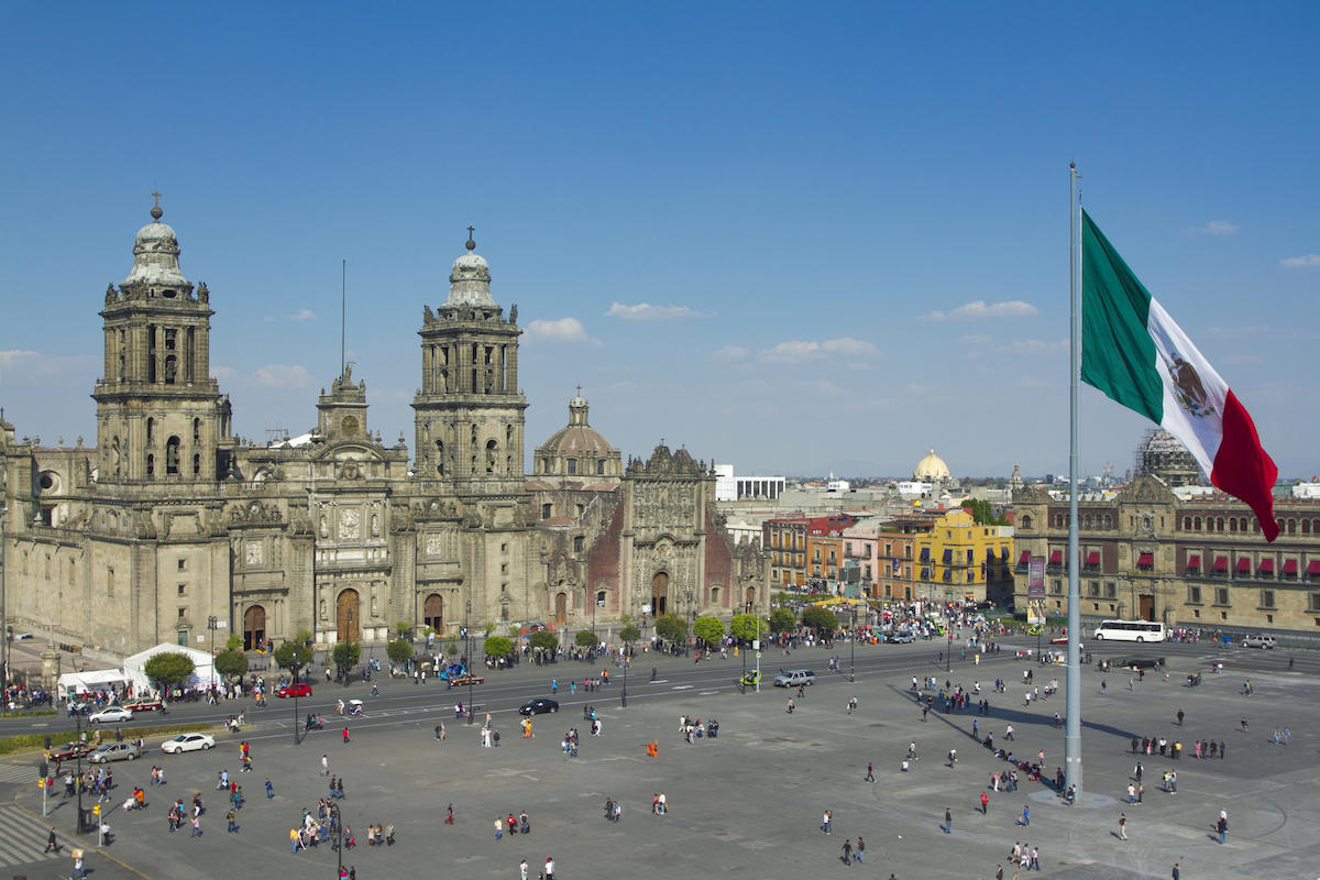 A plaza in Mexico City, with a cathedral and giant flag in the centre