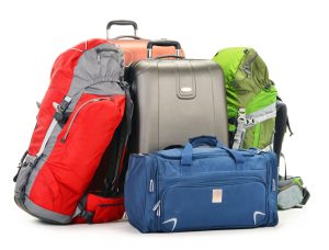 Backpacks and suitcases lying next to one another