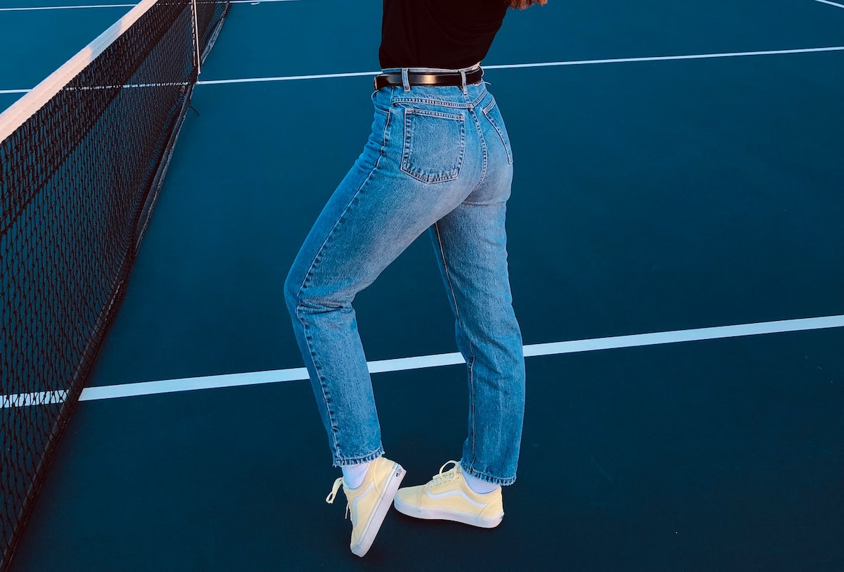 Blue denim jeans worn on a tennis court