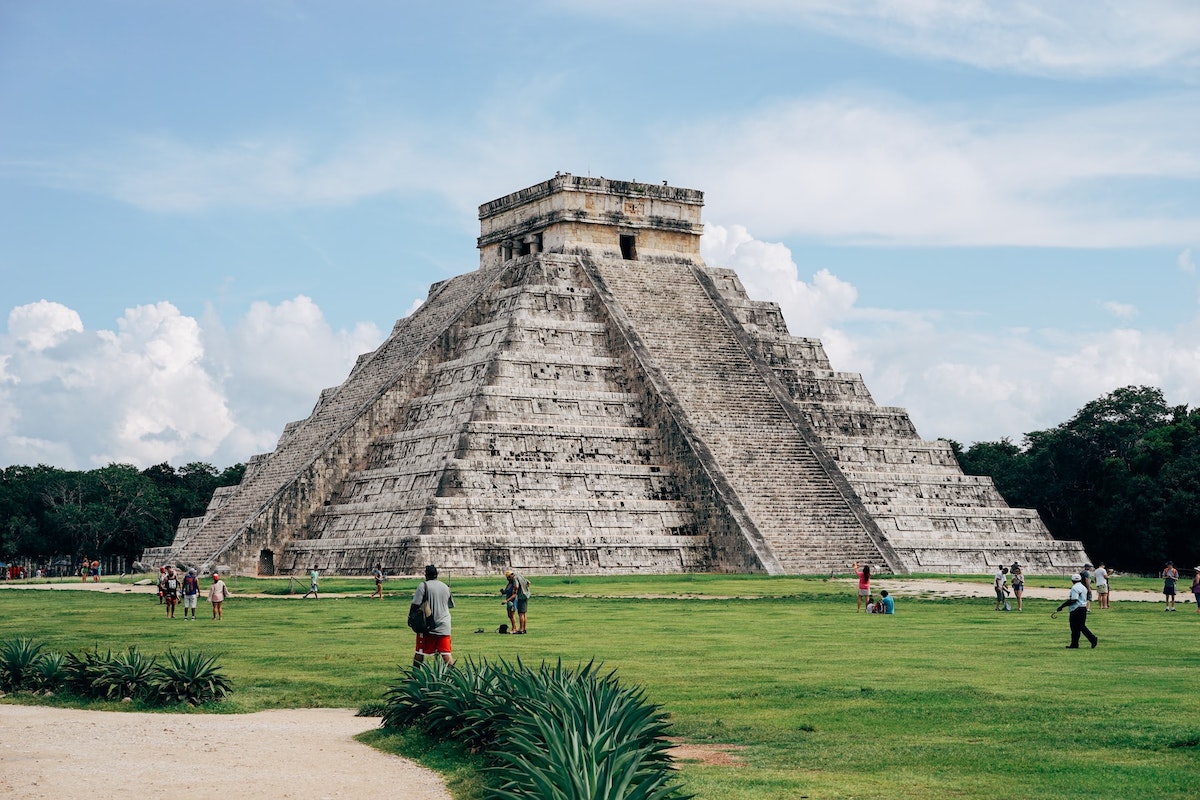 A grey pyramid on the grass during the day in Mexico 