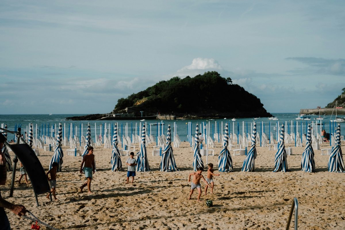 Children playing soccer on sandy beach