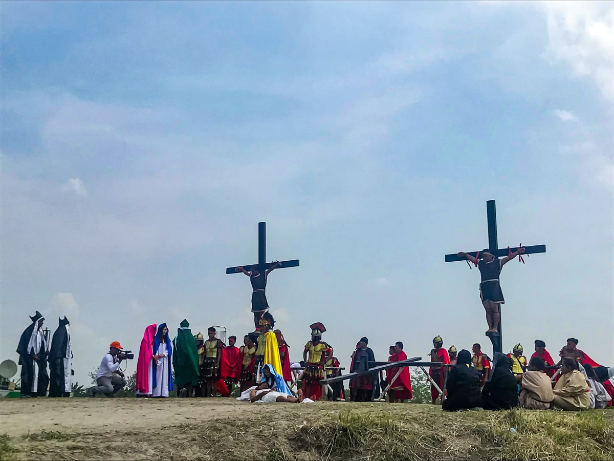 Two men reenact a crucifixion on a raised cross in Pampanga, Philippines 