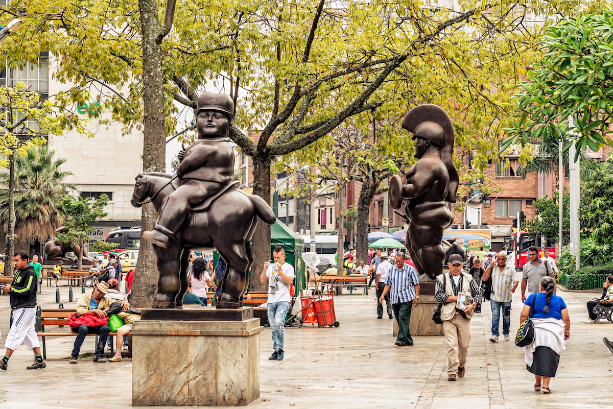 Tourists walking by Botero sculptures located at Botero Plaza in Medellin, Colombia