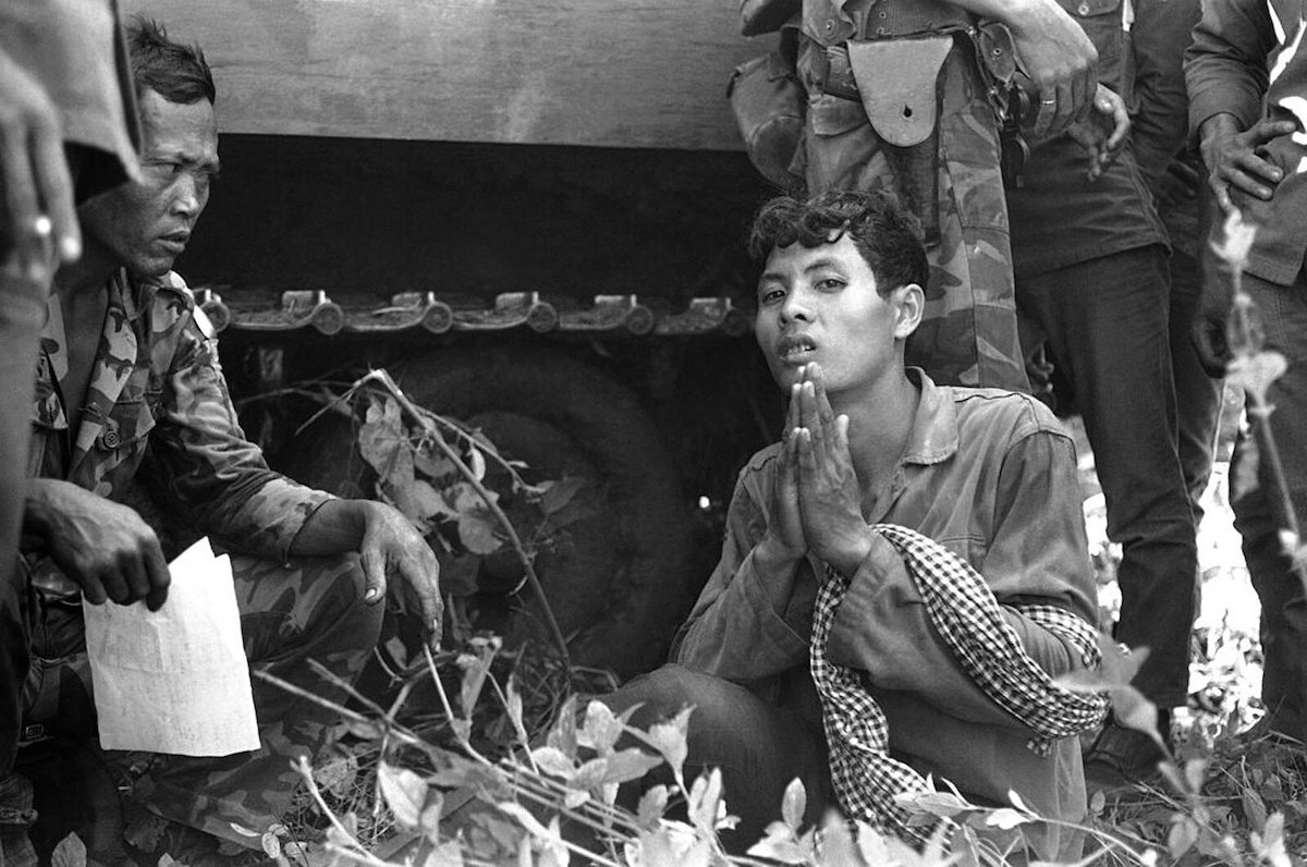 A Cambodian Khmer Rouge soldier begs for mercy during interrogation by Vietnamese troops near the Vietnamese border