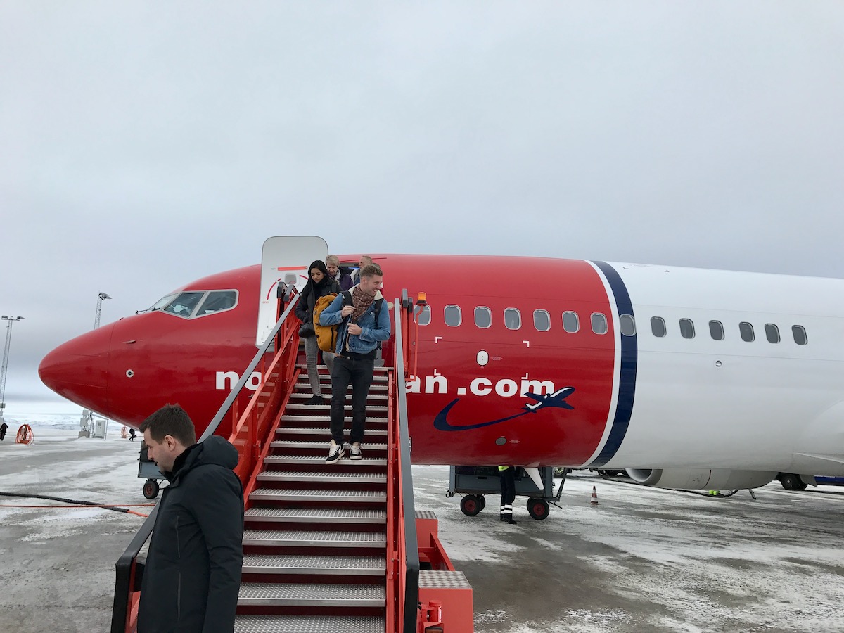 Tourists smiling as they get off a Norwegian Air flight in Kirkenes, Norway.