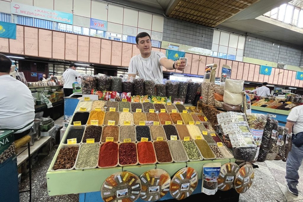 Trays of brightly coloured spices and nuts at a Green Bazaar stall in Almaty