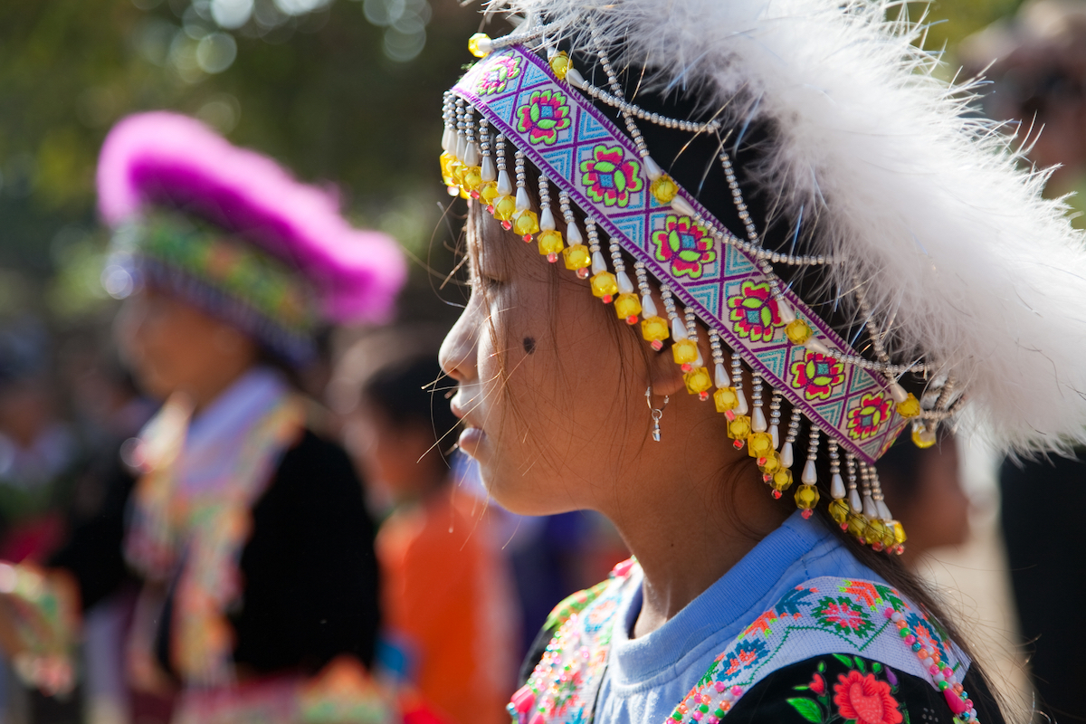 A Hmong child wears a colourful traditional head dress at an annual festival