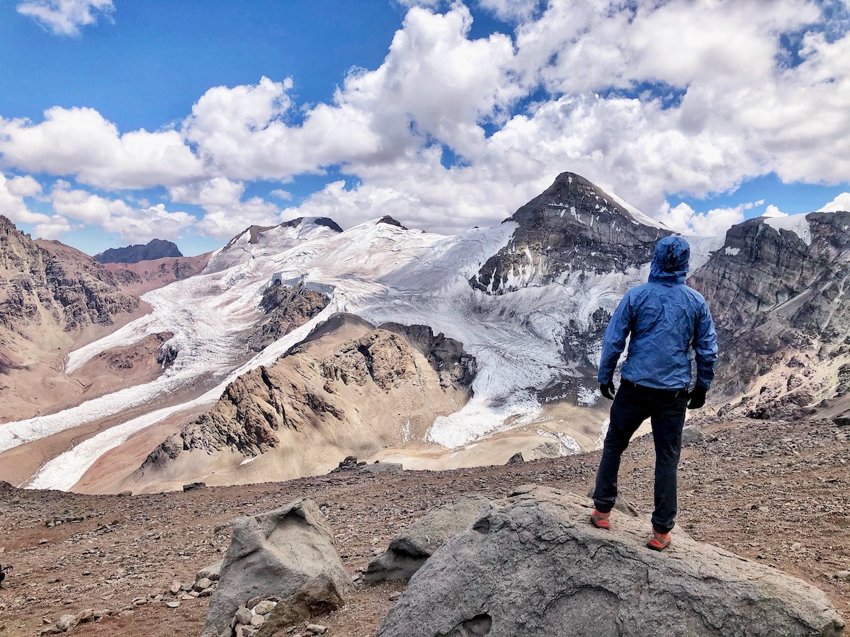 A mountain climber in a blue-hooded jacket stares out into the horizon pondering the question' how hard is it to climb Aconcagua?

He is soon to find out.