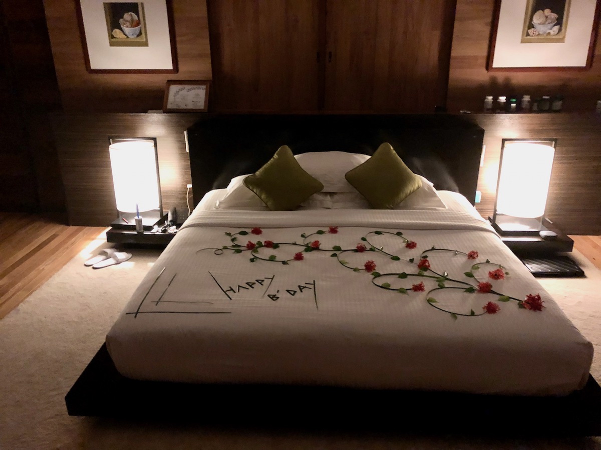 A modern bedroom with "Happy Birthday" decorated on the bed with flowers