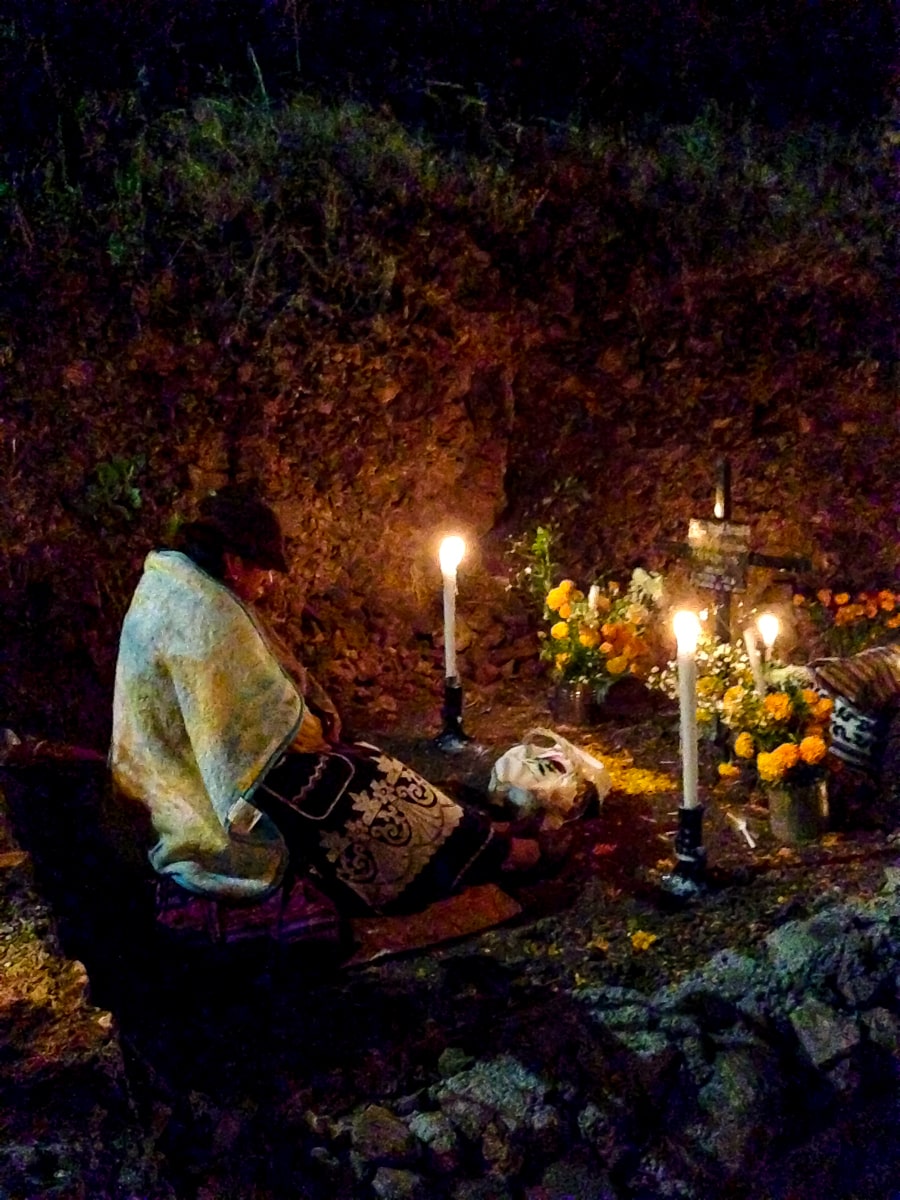 A lady kneels over a grave at The Day of The Dead ceremony on Janitzio Island 