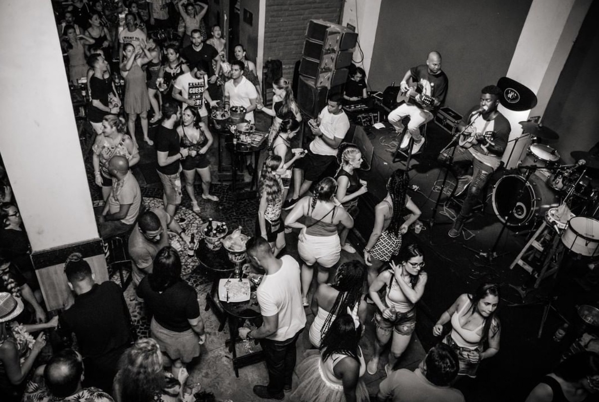 A busy nightclub with live music in black and white filter.