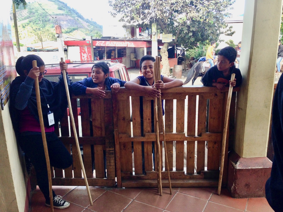 Locals talk as they hold wooden walking sticks for tourists for their hike. 