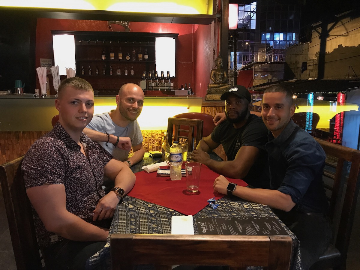 Men sitting at a table smiling. 