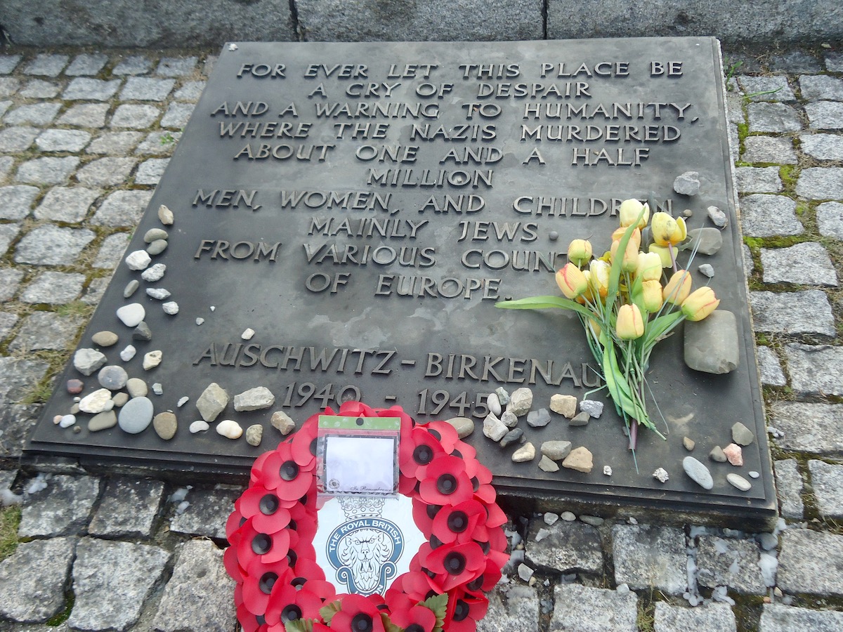 A memorial for the victims of Auschwitz Birkenau with reefs and flowers 