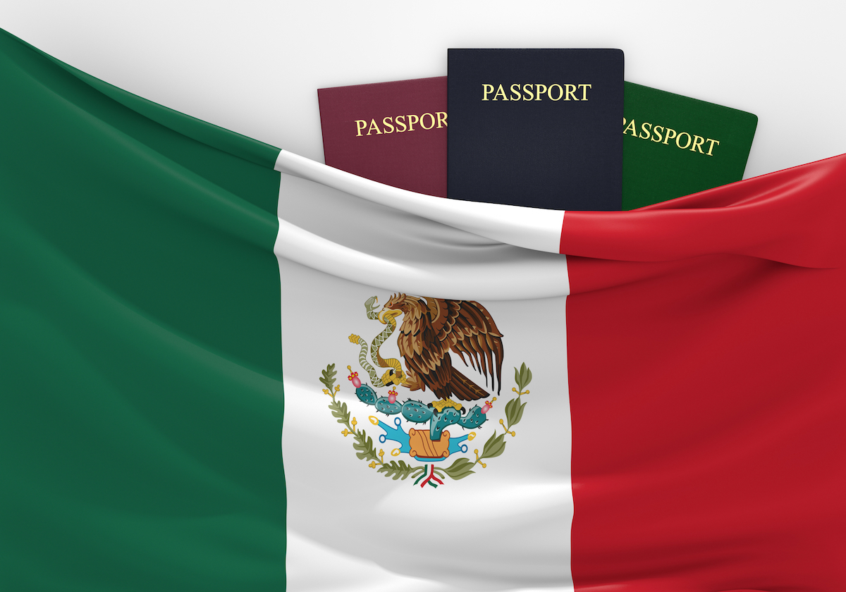 three passports are hidden under a huge flag of Mexico