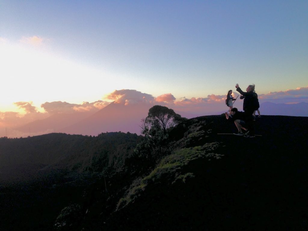 Tourists take photos at sunset at the summit of a volcano in Pacaya, Guatemala.