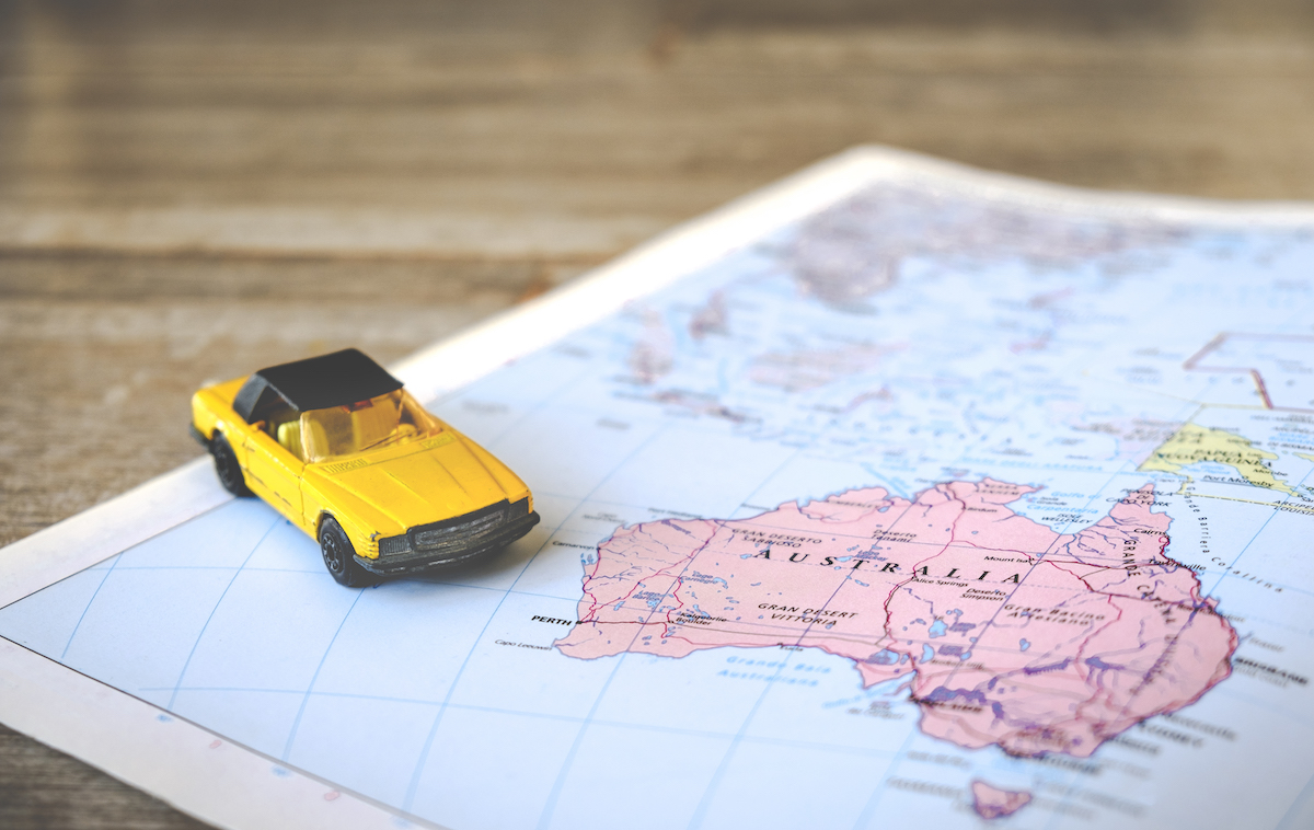 A toy yellow car on a paper map.