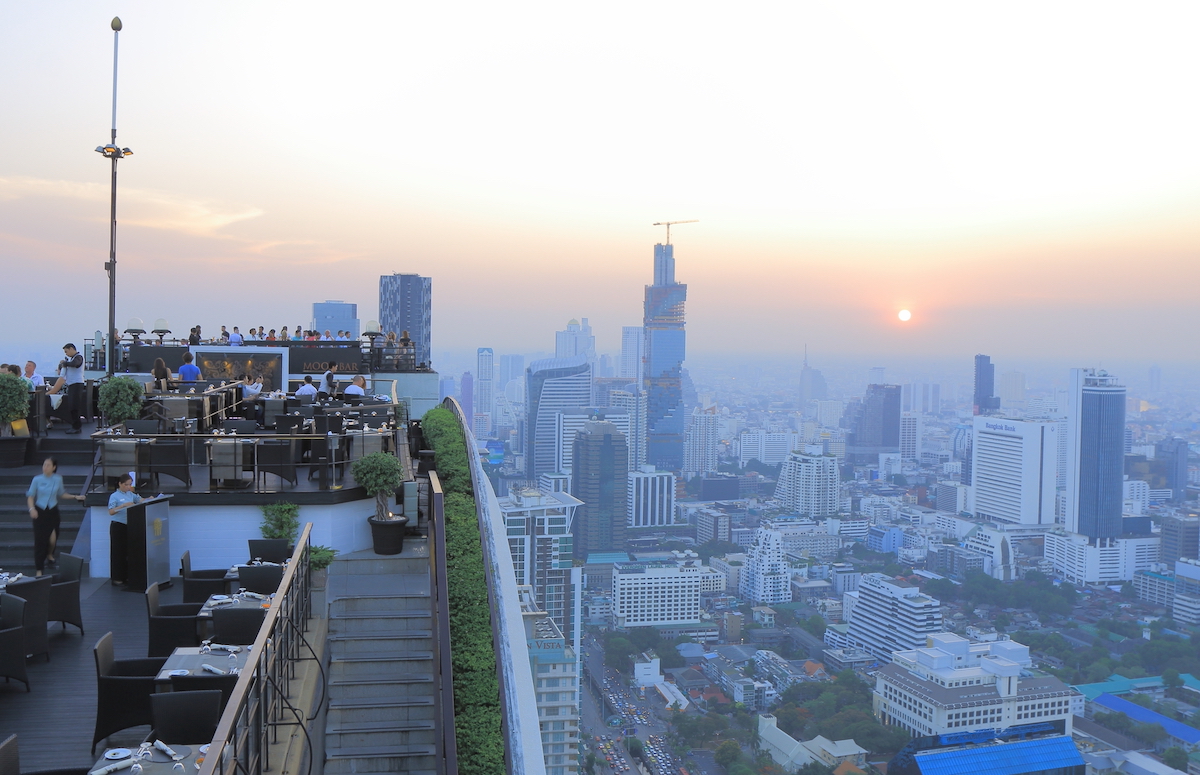 People watch Bangkok city view from a rooftop bar in the business centre of Thailand