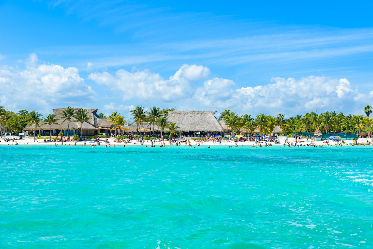 Bodies of people on a beautiful beach with blue clear water.