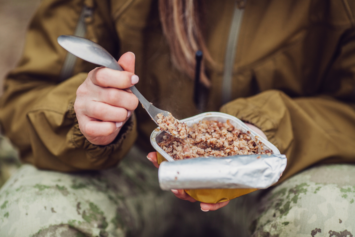 A camper eating food with a spork