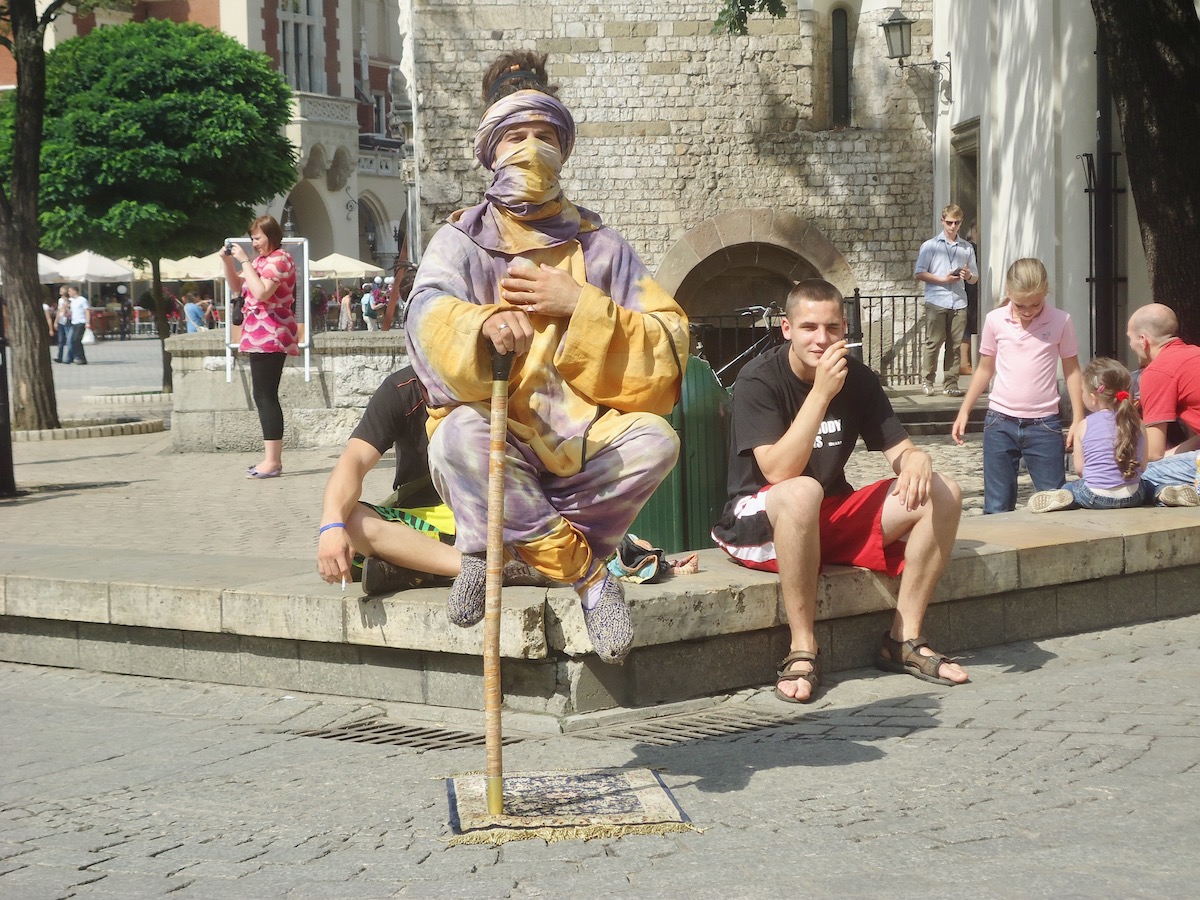 A street performer with a wrapped up face levitates in Krakow, Poland 