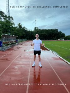 A runner smiles on a stormy running track after running 10k in under 40 minutes