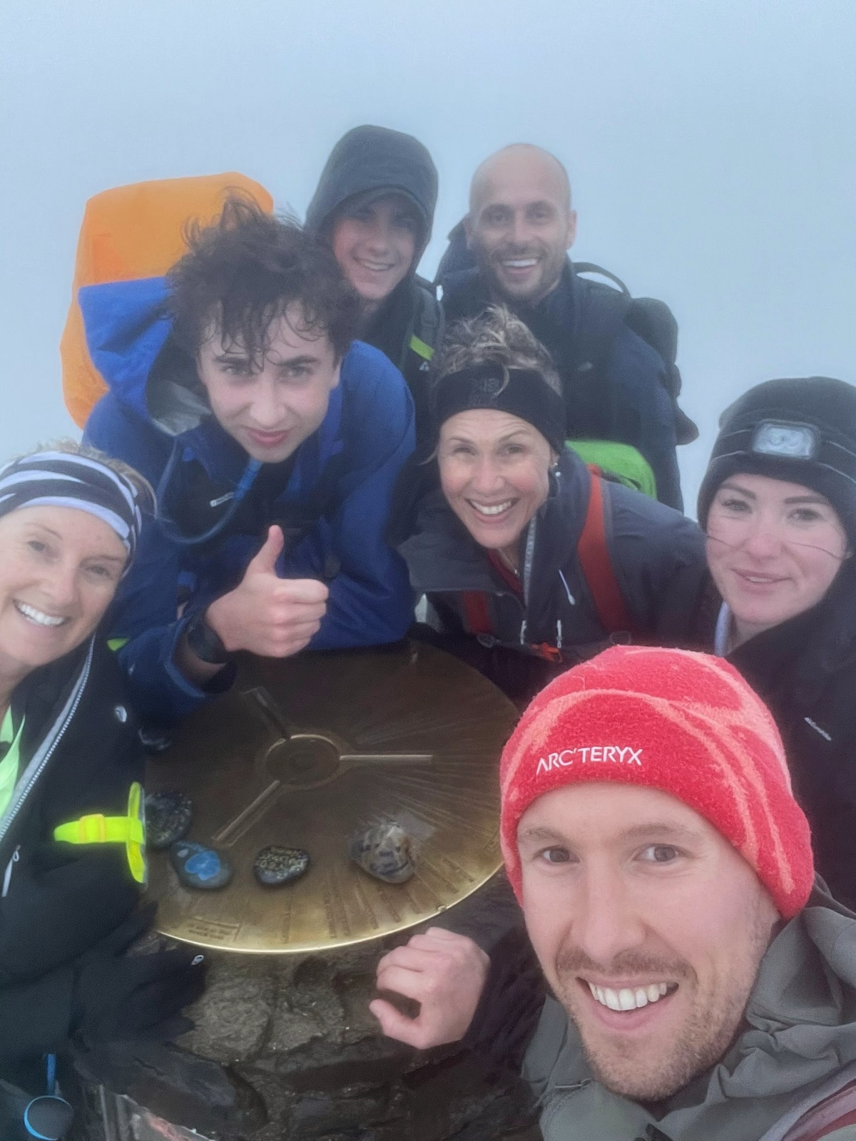 Hikers smile at the top of Mount Snowdon, Wales