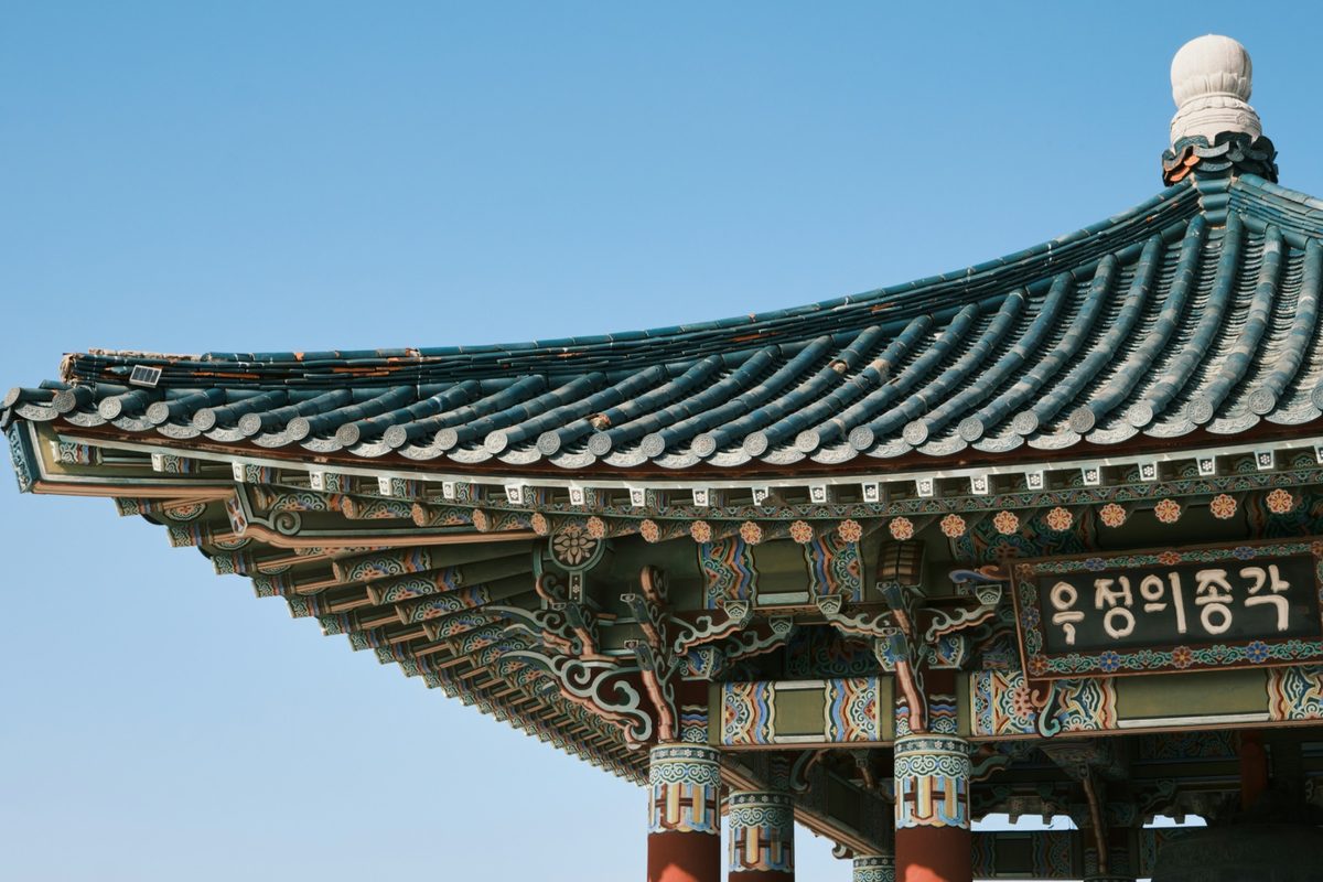 Traditional korean pavilion roof against a clear blue sky