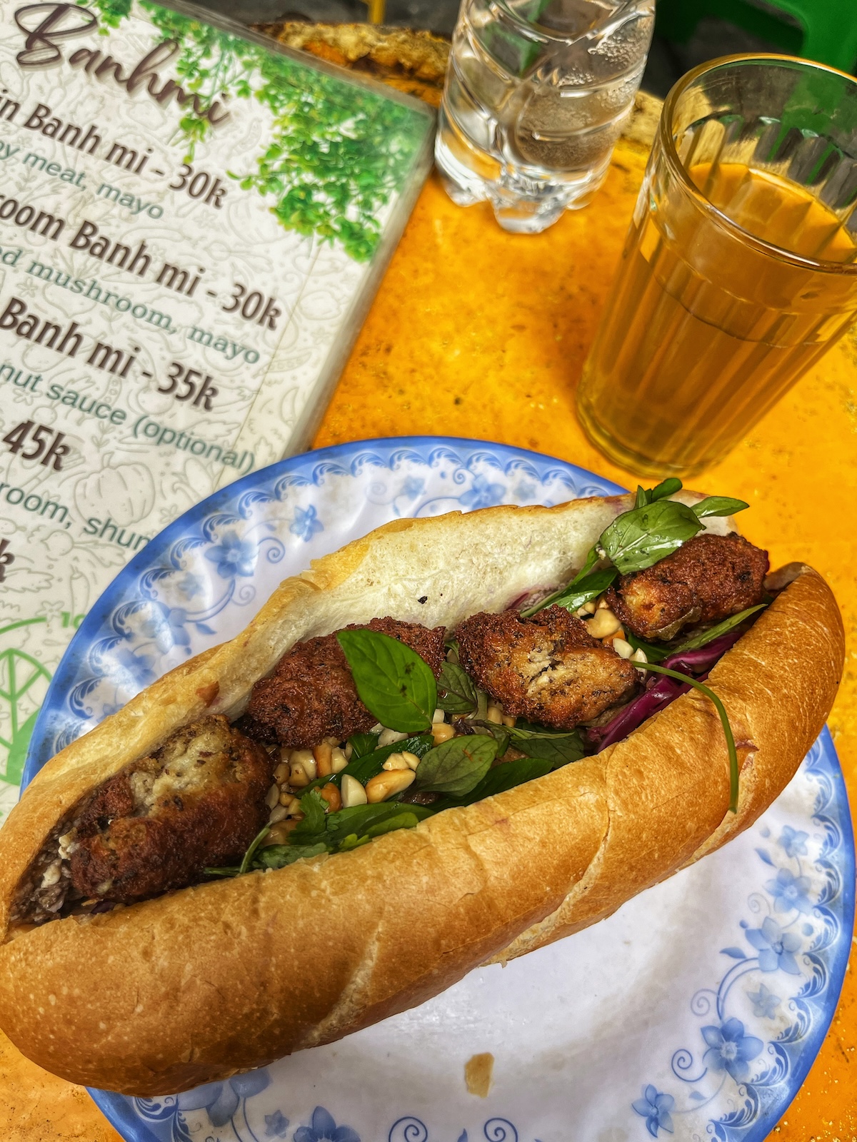 An open sandwich baguette with faux meat, garlic, pine nuts and greens. Banh Mi is a staple lunch in Hanoi.