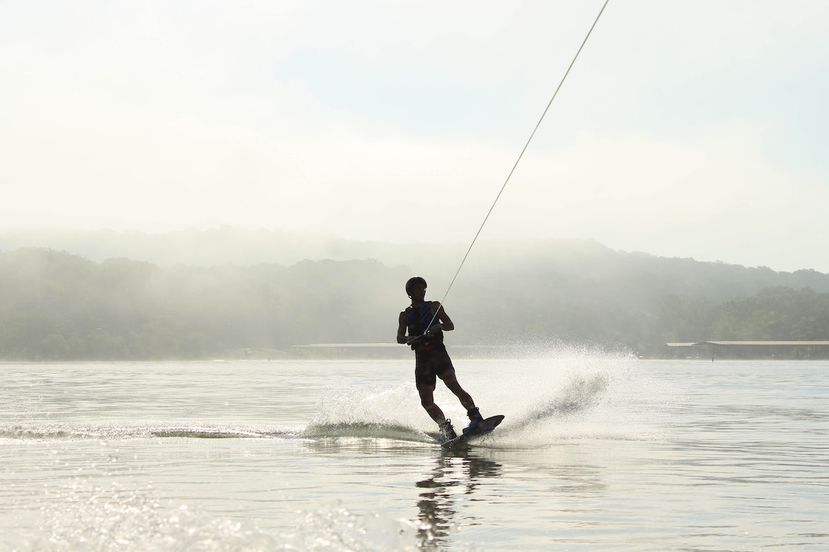 A man wakeboarding on a misty day. 