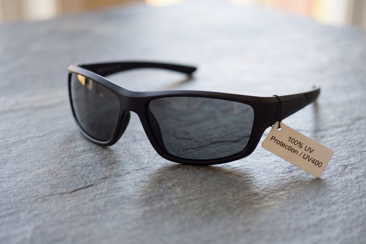 Best Sunglasses After Cataract Surgery: What to Look For | wraparound sunglasses uv400 label Black wraparound sunglasses with a tag reading 100% UV protection and UV400